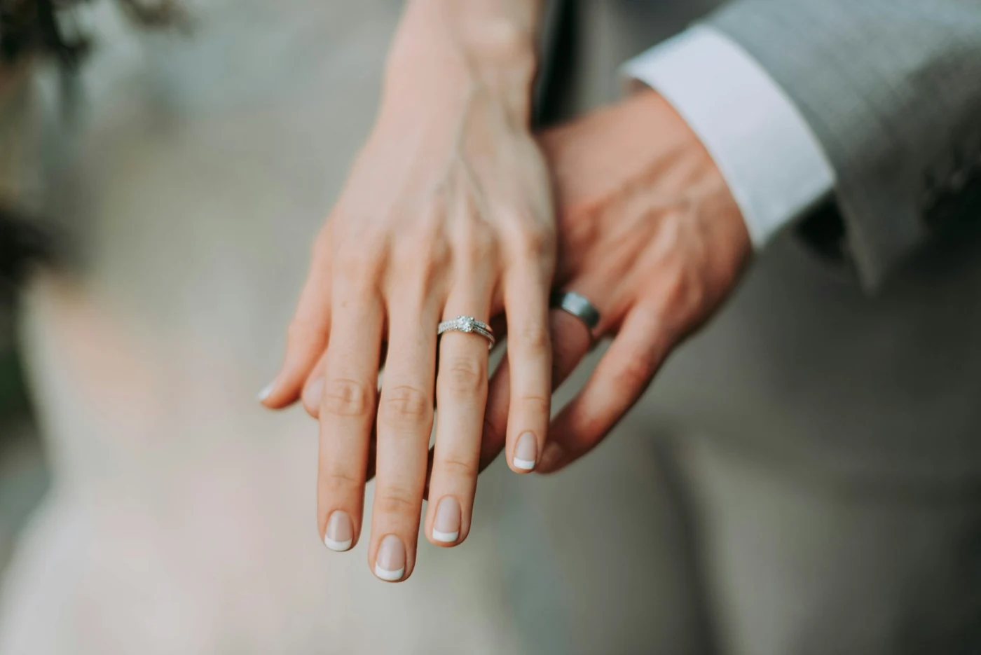 Close-up of a bride’s hand resting over the groom’s hand